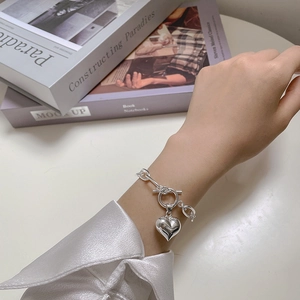 Detailed view of silver heart pendant bracelet with OT toggle clasp worn on wrist