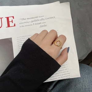 Nahaufnahme eines goldenen, mehrlagigen offenen Rings im minimalistischen Stil