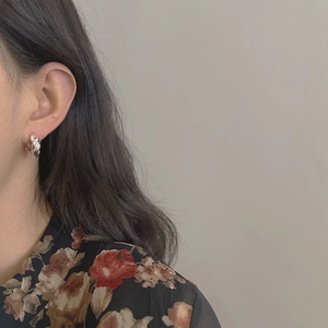 Detail of twisted rope S925 sterling silver hoop earrings worn by a model