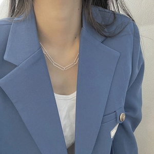 Collier minimaliste en argent S925 à maillons trombone porté par mannequin en blazer bleu