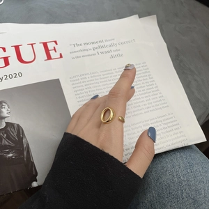 Detailansicht eines vergoldeten, hohlen ovalen Rings an einem Model im modernen Stil