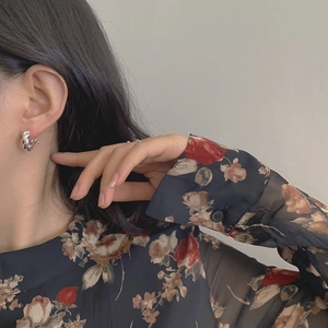 Close-up of S925 sterling silver hoop earrings with twisted rope design on model ear