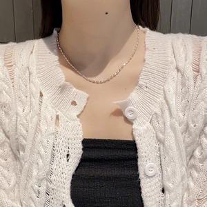 Gros plan d'un collier en argent sterling 925 avec perles olive porté au cou