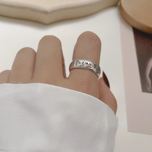 Macro detail of engraved vintage S925 sterling silver ring with ethnic Buddhist mantra