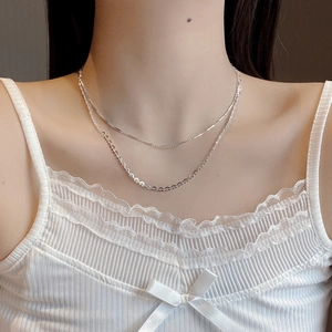 Close-up of a double-layer S925 silver heart necklace on model with white lace outfit