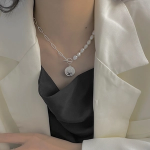 Détail du collier de perles baroques et chaîne argentée avec pendentif pièce sur mannequin