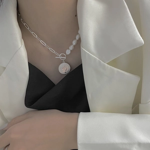 Détail du collier de perles baroques et chaîne en argent avec pendentif pièce sur mannequin