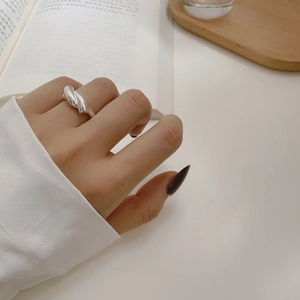 Close-up of minimalist 925 sterling silver cross ring worn on finger with polished finish