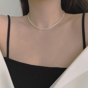 Detail of silver mesh chain necklace on model showing its fine metallic texture and shine