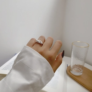 Minimalist 925 sterling silver crossover ring on hand with elegant knotted design
