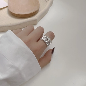 Detail of heavy braided 925 sterling silver ring worn on middle finger for a bold look