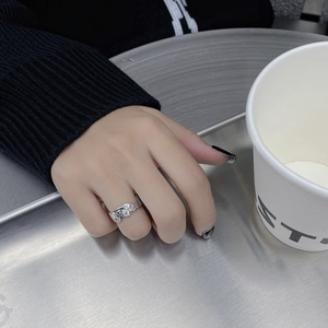 Gros plan sur bague en argent texturée avec pavage de diamants et pierre centrale ronde