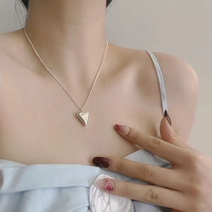 Collana con pendente a cuore in argento sterling S925 lucido indossata da una modella