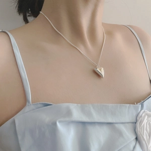 Dettaglio della collana con ciondolo a cuore in argento sterling S925 lucido su una donna