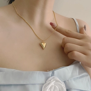 Collana con ciondolo a cuore dorato su modella con finitura lucidata a specchio