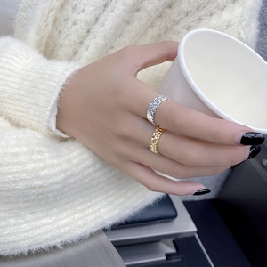 Nahaufnahme von gold- und silberfarbenen Ringen mit Hammerschlag-Muster an der Hand