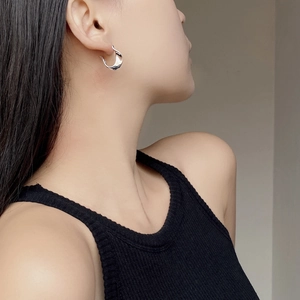Vue rapprochée de la boucle d'oreille torsadée en argent S925 sur l'oreille