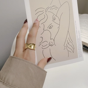 Artistic gold overlapping irregular ring with a glossy finish on a hand model