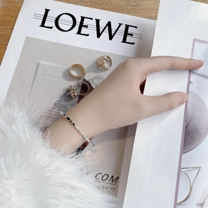 Minimalist silver wavy bangle with micro-pave zircons worn by a model in a modern scene