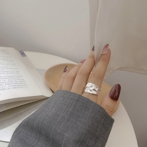 Macro detail of silver S925 ring showing unique irregular hammered texture on wide band