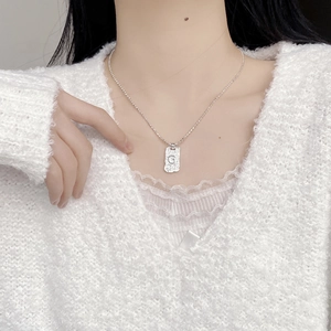 S925 sterling silver G-letter square pendant necklace on model with white sweater