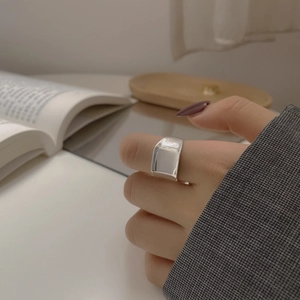 Nahaufnahme eines minimalistischen S925 Silberrings am Finger in einer eleganten Umgebung