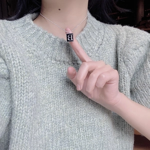 Macro view of S925 sterling silver square black B pendant necklace on collarbone
