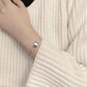 Minimalist double-chain silver bracelet featuring a diamond-quilted rectangular pendant charm