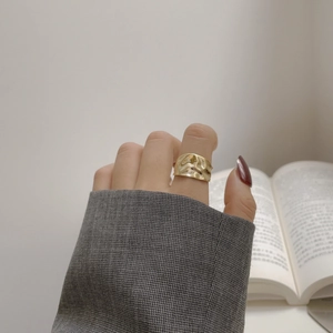 Irregular textured gold S925 sterling silver open ring shown on hand with an elegant book