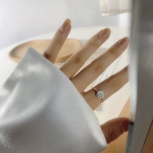 Close-up of a vintage S925 sterling silver bear ring worn on a finger with white satin sleeve