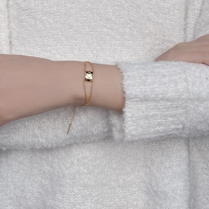 Elegant gold-tone double-chain bracelet with classic quilted pattern rectangle pendant