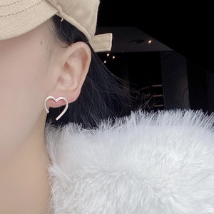 Minimalist S925 sterling silver hollow heart outline stud earrings worn by a model