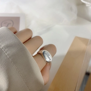 Macro detail of polished S925 sterling silver wide ring featuring Love engraving on the band