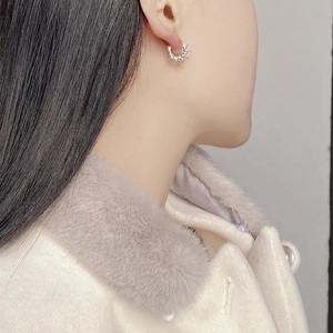 Macro close-up of 925 silver thorn hoop earrings worn on a model ear for detail