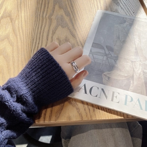 Detailed view of silver crescent moon ring with lava texture on woman's finger
