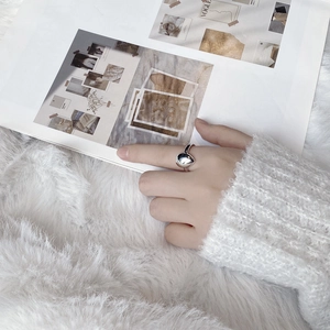 Elegant polished S925 sterling silver water drop ring worn on finger over plush background