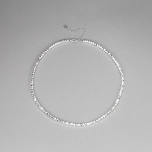 Detailed close-up of faceted silver geometric bead necklace with lobster clasp and chain