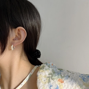 Orecchini geometrici in argento sterling 925 indossati da una modella su sfondo neutro