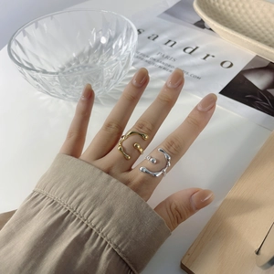 Detailed view of two adjustable molten lava style rings in gold and silver finish