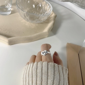 Minimalist S925 sterling silver heart ring with black bow engraving worn by a woman