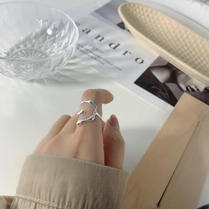 Irregular fluid-style S925 sterling silver ring with cross texture shown on model hand