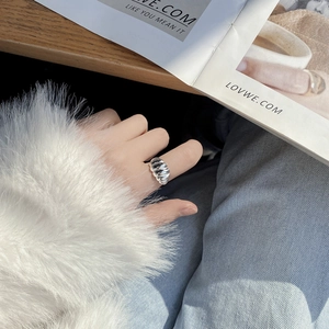 Close-up of S925 sterling silver croissant ring with textured waves on person hand
