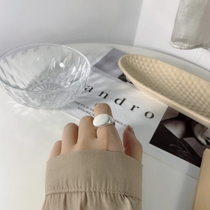 Nahaufnahme eines minimalistischen silbernen Oval-Rings am Mittelfinger im Lifestyle-Look