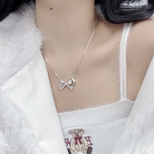 Elegant S925 sterling silver bow pendant necklace worn on a model for autumn fashion