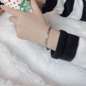 Detail of vintage textured S925 sterling silver open bangle worn on a female wrist