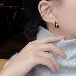 925 Sterling Silver S-curve earrings with a golden finish on a model side view