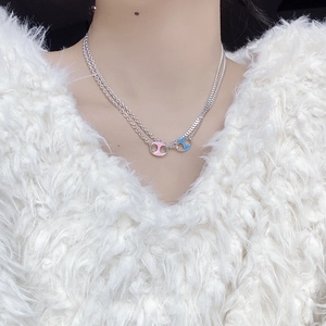 Close-up of double-layer 925 silver necklace with pink and blue enamel pendants
