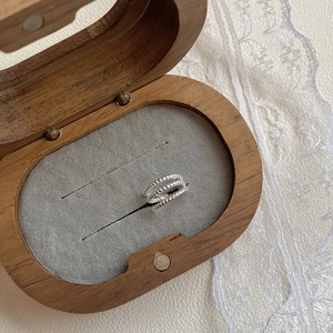 Detailed view of silver multi-layer beaded rings placed in a vintage walnut jewelry box