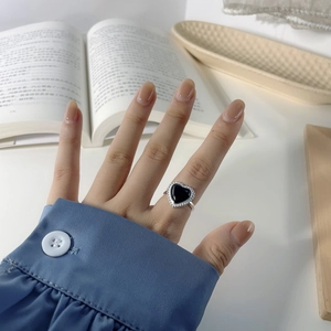 Macro shot of S925 silver ring featuring heart-shaped black agate and beaded edge