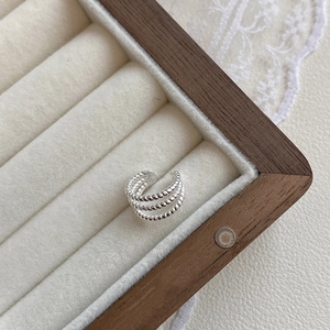 Macro shot of silver triple-layered twisted rope ear cuff in a jewelry box